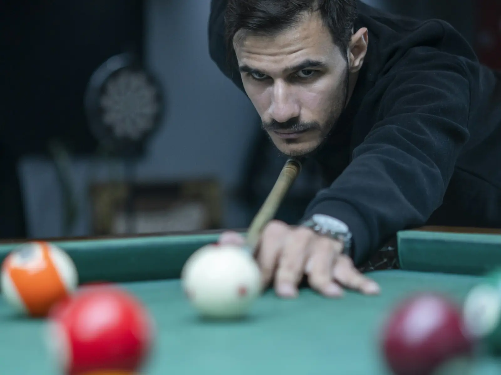 A player lining up a shot on a pool table